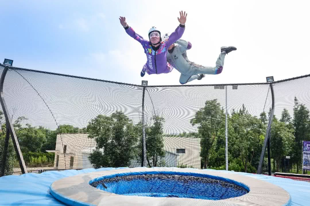 游客在教练的保护下体验风洞"飞行"