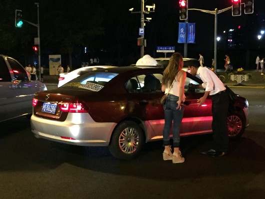 图片说明:两名外国游客被这辆"沪dx"牌照出租车的"报价"搞懵了.